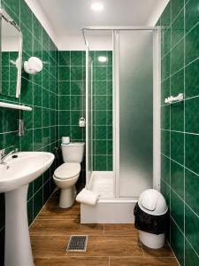 a green tiled bathroom with a toilet and a shower at Amphora Kompleks Wypoczynkowy in Krynica Zdrój +83 photos
