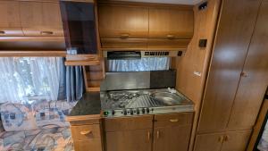 a kitchen with a stove and a sink in an rv at Mikael's Bed & Spa - Camping Suite in Sandefjord