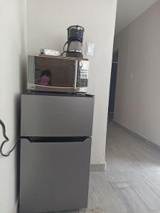 eine Mikrowelle, die auf einem Kühlschrank steht in der Unterkunft Hostal Batarse Centro in Torreón