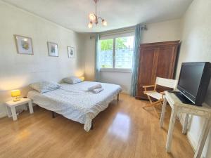 a bedroom with a bed and a flat screen tv at Vir'Volcans - Terrasse Parking Garage privatif in Romagnat