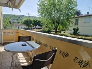 a patio with a table and chairs on a balcony at Vir'Volcans - Terrasse Parking Garage privatif in Romagnat