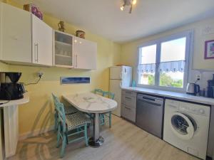 a small kitchen with a table and a laundry machine at Vir'Volcans - Terrasse Parking Garage privatif in Romagnat