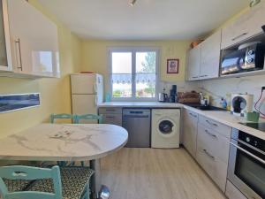 a kitchen with a table and a sink and a dishwasher at Vir'Volcans - Terrasse Parking Garage privatif in Romagnat
