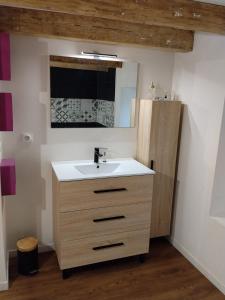 a bathroom with a sink and a wooden cabinet at Maison de charme a moye in Moye