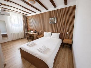 a bedroom with a large bed and a desk at Confort INN in Otopeni