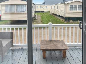 a table on a porch with a view of a house at Pebbles in Pakefield +3 photos