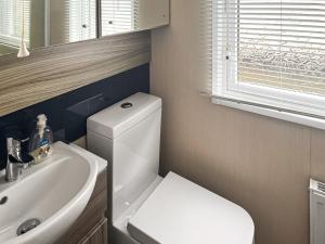 a bathroom with a white toilet and a sink at Pebbles in Pakefield
