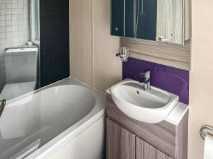 a bathroom with a sink and a tub and a toilet at Pebbles in Pakefield