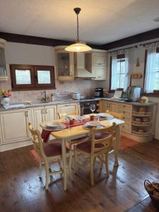 a kitchen with a wooden table with chairs and a table and a table at Родопски Рай in Slaveino