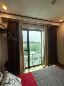 a bedroom with a bed and a large glass window at A Comfy Place in Tagaytay in Sampong +6 photos
