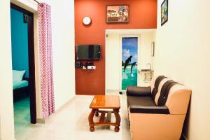 a living room with a couch and a table at Mercury JKR Residency in Yelagiri +24 photos