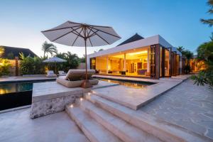 a house with a pool and an umbrella at Private Oceanfront Villa Kingfisher - 20m Infinity Pool in Nusa Lembongan +57 photos