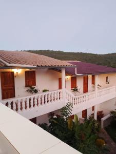 a white house with a balcony and trees in the background at Villa Manga Rosa in Lençóis