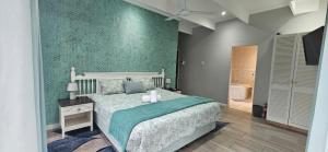a bedroom with a bed and a green wall at Daniel's Sunset Garden in Richards Bay +11 photos