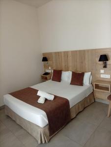 a bedroom with a large bed with two towels on it at Hotel La Florida in Seville