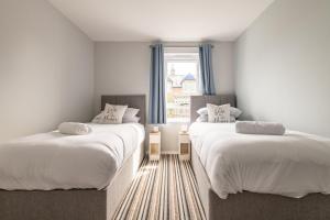 two beds in a room with a window at Admiralty Lane - No 4 in Elie
