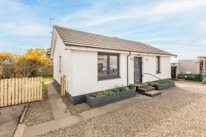 a white house with plants in front of it at Admiralty Lane - No 4 in Elie