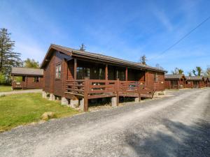 a large wooden cabin on a dirt road at Lodge 1 - Bron Eifion in Criccieth