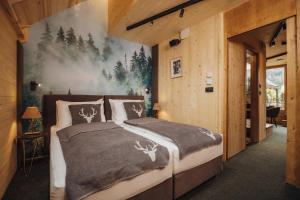a bedroom with a bed with a forest mural on the wall at JASNA NATUR Resort by the lake in Kranjska Gora +144 photos