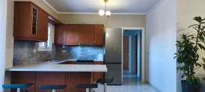 a kitchen with wooden cabinets and a stainless steel refrigerator at Golden rose in Corfu