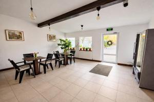 a dining room with tables and chairs and a kitchen at Confort INN in Otopeni