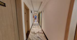 a corridor of a building with a marble floor at The Royal Ark Hotel in Pune