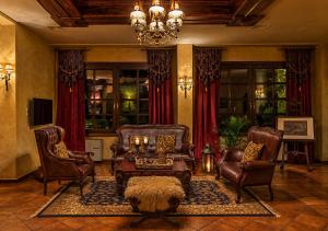 a living room with leather furniture and a chandelier at Hotel Doupiani House in Kalabaka +28 photos