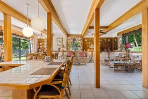 a dining room with a large wooden table and chairs at Hale Kamāoa Naalehu in Naalehu