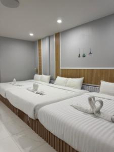 two beds in a room with white sheets at Cozy Clover house in Hat Yai +32 photos