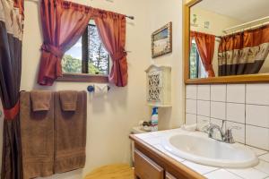 a bathroom with a sink and a mirror at Hale Kamāoa Naalehu in Naalehu +18 photos