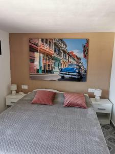 a bedroom with a bed with a painting on the wall at Casa del Sol in Gandía +55 photos