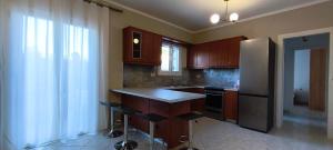 a kitchen with wooden cabinets and a refrigerator and a counter at Golden rose in Corfu