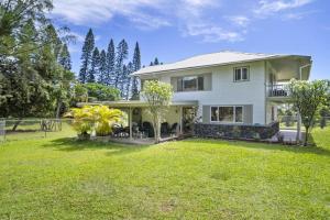 a large white house with a yard at Hale Kamāoa Naalehu in Naalehu