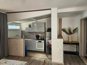 a kitchen with white cabinets and a table in a room at "Azzurra Apartments in Molunat