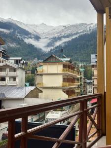 a balcony with a view of a snowy mountain at Hexon Stays in Manāli