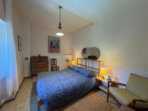 a bedroom with a bed and a couch and a chair at Villa delle Fonti - Villa With Pool in Toano +20 photos