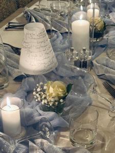 ein Tisch mit Kerzen, einer Lampe und Blumen darauf in der Unterkunft Hotel Holzer in Sexten + 104 Fotos