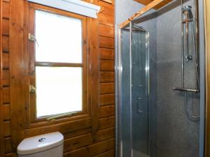 a bathroom with a shower and a toilet and a window at Lodge 4 - Bron Eifion in Criccieth +25 photos