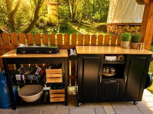 a wooden table with a counter with a sink and a counter at Jurty u jezírka in Mostek