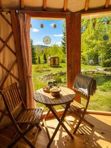 a table and a chair in a room with a window at Jurty u jezírka in Mostek +32 photos