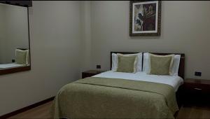 a bedroom with a bed and a picture on the wall at Rritja e Koranit in Pogradec