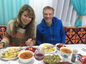 a man and woman sitting at a table with food at Syimyk Guest House in Dzhergalan