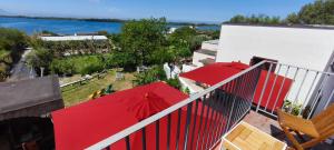 two red umbrellas sitting on top of a balcony at Guesthouse Acherusia in Bacoli