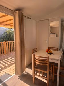 a room with a table and chairs on a deck at Escale Sud in Canet-en-Roussillon