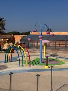 a playground in a park with many different colored rides at Escale Sud in Canet-en-Roussillon