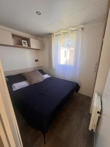 a small bedroom with a black bed and a window at Escale Sud in Canet-en-Roussillon +19 photos