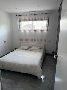 a white bedroom with a bed with a window at Villa avec piscine jacuzzi et sauna in Saint-André-de-Cubzac +21 photos