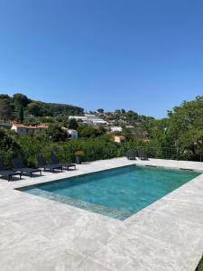 a swimming pool with chairs and a view at Bas de villa indépendant prestations haut de gamme in Vallauris