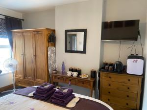 a bedroom with a bed with purple towels on it at Butterfly House in Blackwood