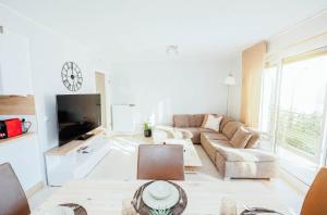 a white living room with a couch and a tv at Stunning 2 bed Mamer free parking in Mamer